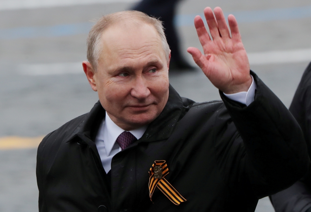 Russian President Vladimir Putin waves while walking along Red Square after a military parade on Victory Day, which marks the 76th anniversary of the victory over Nazi Germany in World War Two, in central Moscow, Russia May 9, 2021. REUTERS/Evgenia Novozh