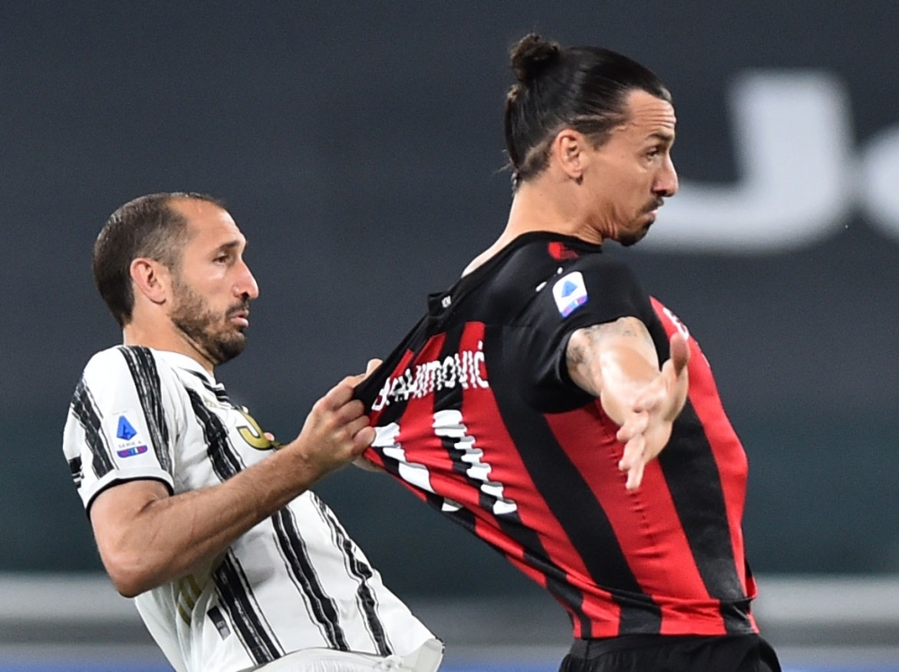 AC Milan's Zlatan Ibrahimovic in action with Juventus' Giorgio Chiellini REUTERS/Massimo Pinca