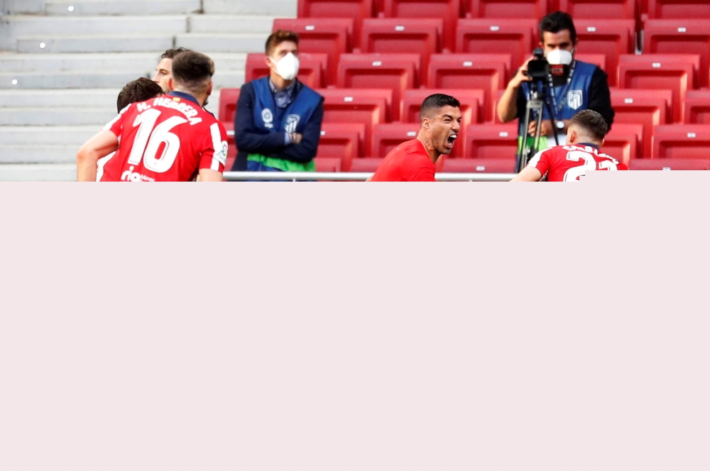 Atletico Madrid's Luis Suarez celebrates scoring their second goal with teammates as Osasuna players look dejected REUTERS/Juan Medina 