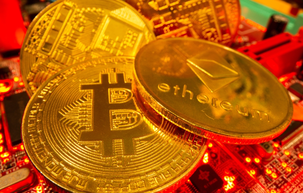 :Representations of the virtual currency Bitcoin and Ethereum stand on a motherboard in this picture illustration taken May 20, 2021. (REUTERS)