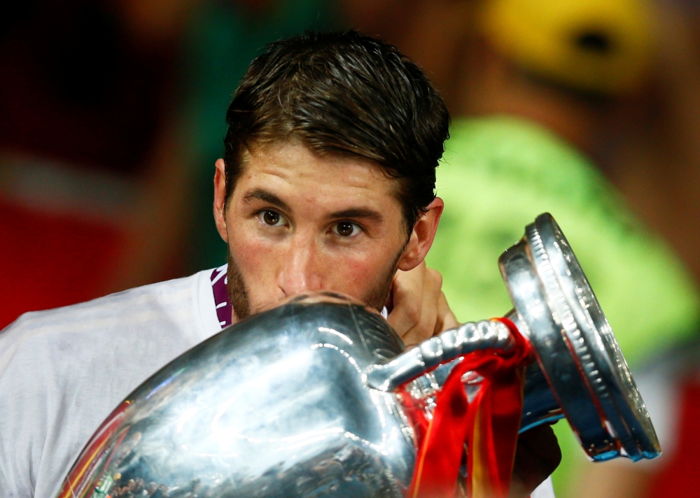 FILE PHOTO: Spain's Sergio Ramos kisses the trophy after defeating Italy to win the Euro 2012 final soccer match at the Olympic stadium in Kiev, July 1, 2012. REUTERS/Kai Pfaffenbach