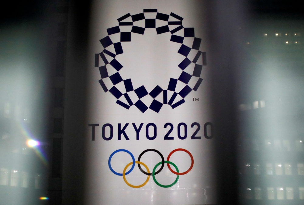 The logo of Tokyo 2020 Olympic Games that have been postponed to 2021 due to the coronavirus disease (COVID-19) outbreak, is seen through signboards, at Tokyo Metropolitan Government Office building in Tokyo, Japan January 22, 2021. REUTERS/Issei Kato/Fil