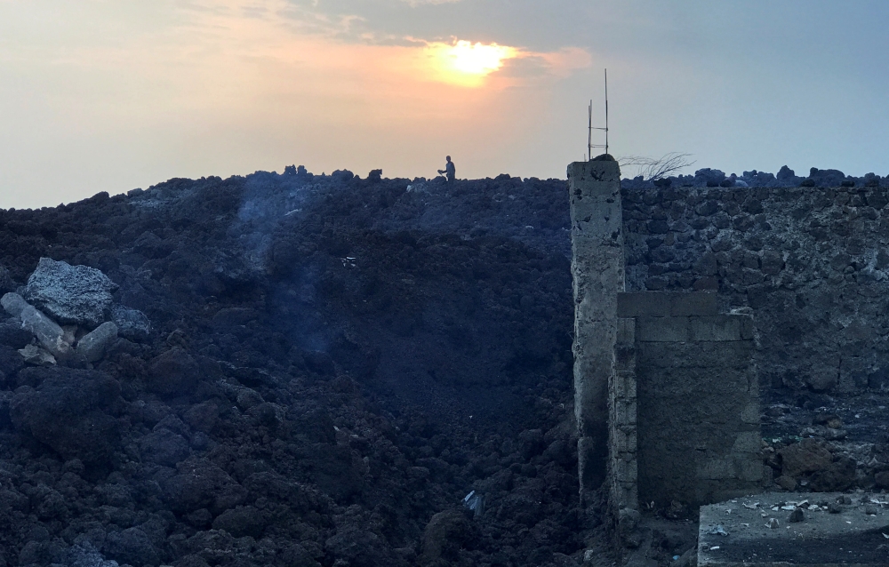 A resident picks up remains from their home which is covered with smouldering lava after the eruption of Mount Nyiragongo volcano, near Goma, in the Democratic Republic of Congo May 24, 2021. Reuters/Djaffar Al Katanty