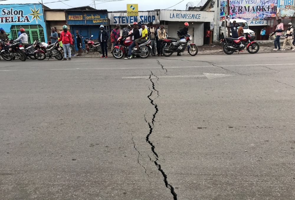 Congolese riders are seen near a crack on the road caused by earth tremors as aftershocks following the eruption of Mount Nyiragongo volcano near Goma, in the Democratic Republic of Congo May 26, 2021. Reuters/Djaffar Al Katanty