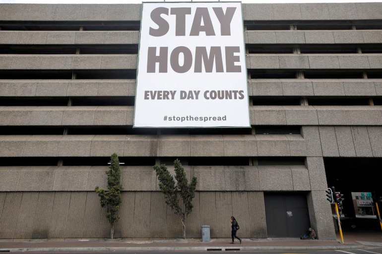 FILE PHOTO: A man walks beneath a billboard during the 21-day nationwide lockdown aimed at limiting the spread of coronavirus disease (COVID-19) in central Cape Town, South Africa, April 6, 2020. REUTERS/Mike Hutchings
