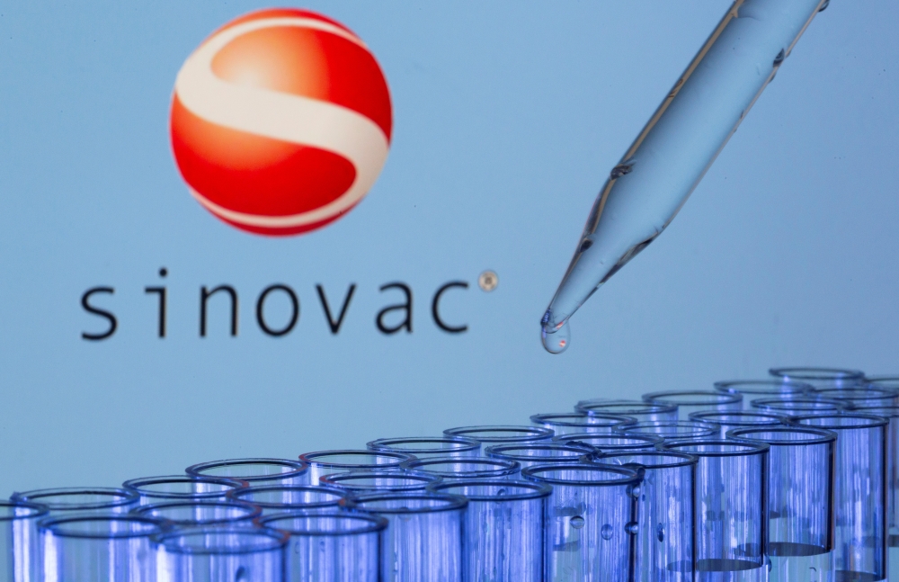 FILE PHOTO: Test tubes are seen in front of a displayed Sinovac logo in this illustration taken, May 21, 2021. REUTERS/Dado Ruvic/Illustration