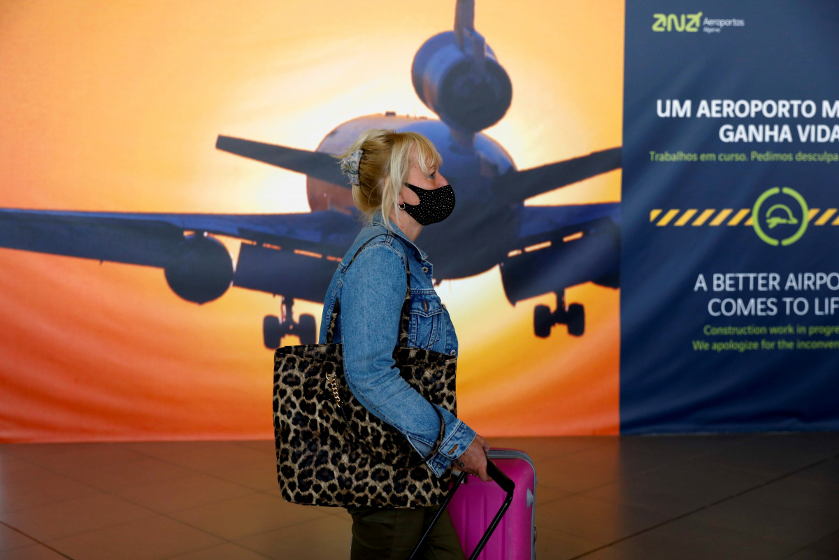 FILE PHOTO: A woman arrives at Faro Airport on the first day that Britons are allowed to enter Portugal without needing to quarantine, as coronavirus disease (COVID-19) restrictions are eased, in Faro, Portugal, May 17, 2021. REUTERS/Pedro Nunes/File Phot