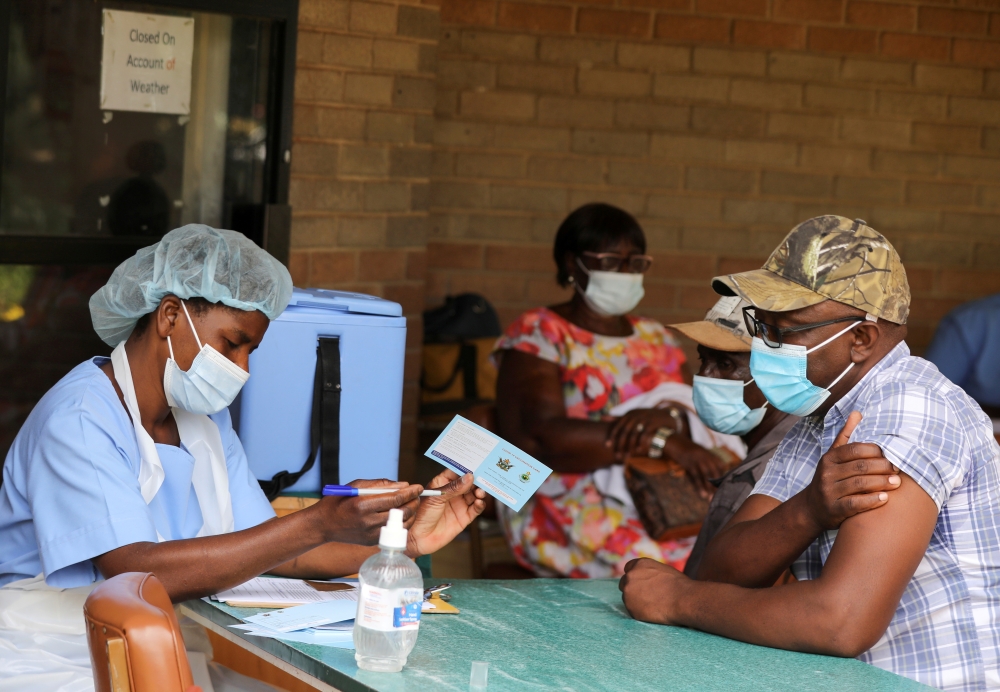 A man receives a certificate after being vaccinated against the coronavirus disease (COVID-19) at Wilkins Hospital in Harare, Zimbabwe, March 24, 2021. REUTERS/Philimon Bulawayo/File Photo