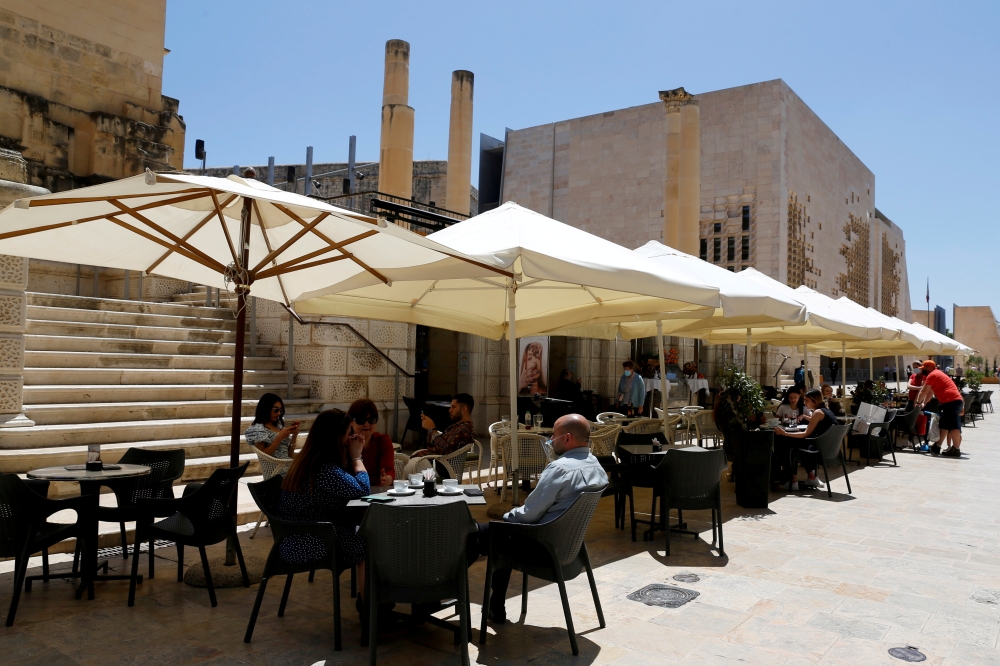 People sit at an outdoor restaurant as restaurants and markets reopened for business after coronavirus disease (COVID-19) vaccinations reached 60% of the adult population, in Valletta, Malta May 10, 2021. REUTERS/Darrin Zammit Lupi/File Photo