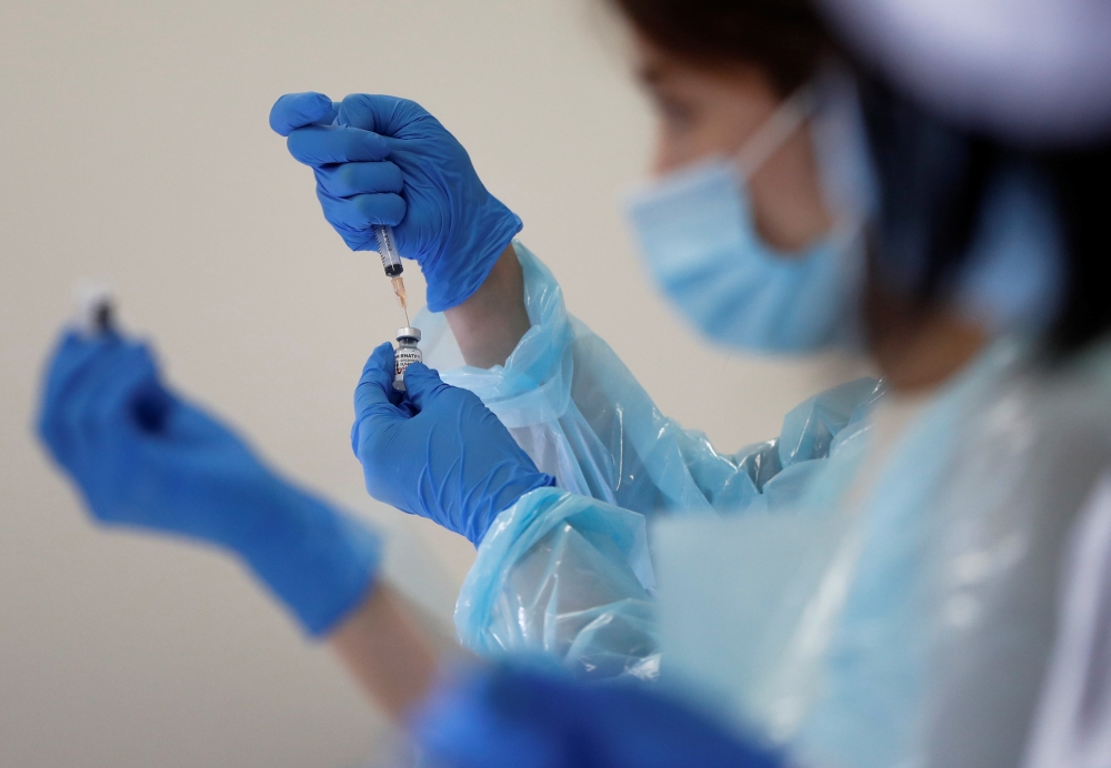A health worker fills a syringe with a dose of the Pfizer-BioNTech coronavirus disease (COVID-19) vaccine at the Noevir Stadium Kobe, in Kobe, Japan on June 12, 2021. (REUTERS/Issei Kato)