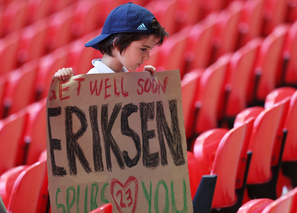 A fan holds a banner of support for Denmark's Christian Eriksen after he collapsed on the pitch during his side's Euro 2020 match with Finland Pool via Reuters/Catherine Ivill