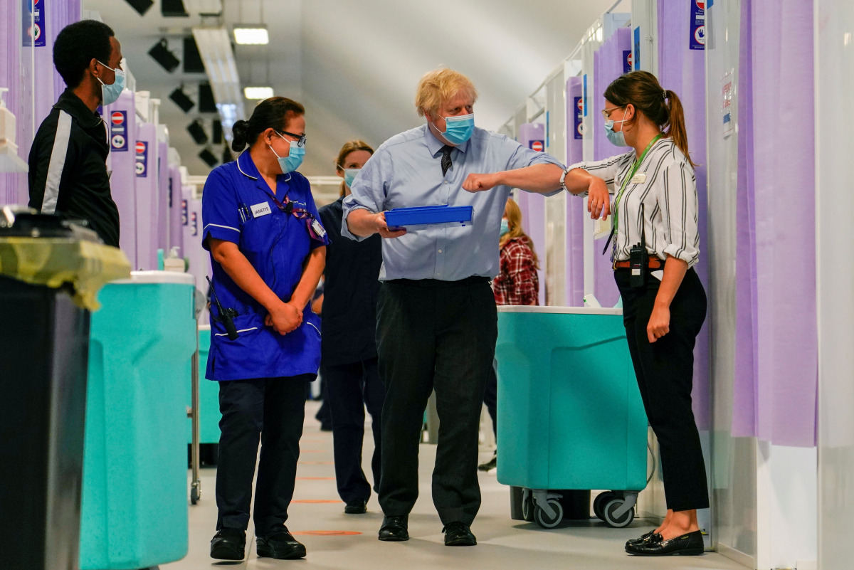 Britain's Prime Minister Boris Johnson greets a woman during a visit in a vaccination centre at the StoneX Stadium, home of the rugby club Saracens, amid coronavirus disease (COVID-19) pandemic, in North London, Britain June 21, 2021. Alberto Pezzali/Pool