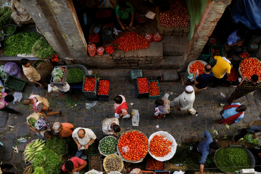 People shop at a crowded wholesale vegetable market after authorities eased coronavirus restrictions, following a drop in the coronavirus disease (COVID-19) cases, in the old quarters of Delhi, India, June 23, 2021. REUTERS/Adnan Abidi