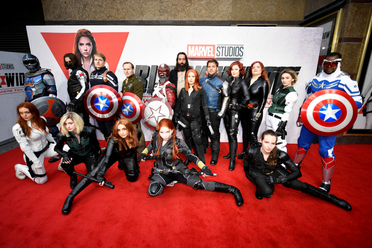 Fans dressed as Avengers characters pose for a picture during a special fan event for the Marvel film 