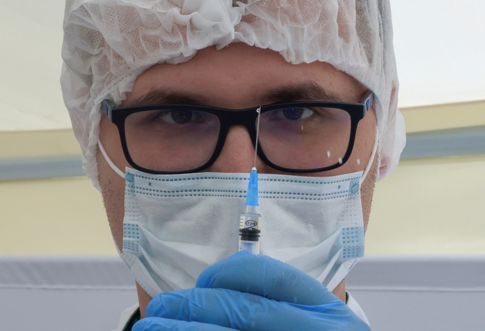 A healthcare worker holds a syringe with the one-dose Sputnik Light vaccine against the coronavirus disease (COVID-19) in a vaccination centre at a city market in Moscow, Russia, June 30, 2021. REUTERS/Tatyana Makeyeva/File Photo