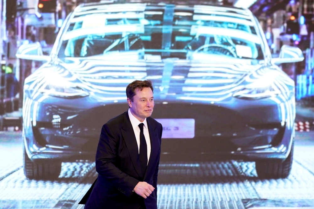 FILE PHOTO: Tesla Inc CEO Elon Musk walks next to a screen showing an image of Tesla Model 3 car during an opening ceremony for Tesla China-made Model Y program in Shanghai, China January 7, 2020. REUTERS/Aly Song