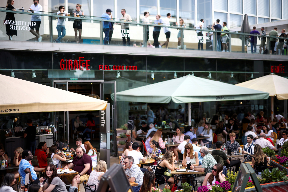 FILE PHOTO: People sit at an outdoor restaurant on the South Bank during sunny weather, amid the coronavirus disease (COVID-19) outbreak, in London, Britain, June 5, 2021. REUTERS/Henry Nicholls/File Photo
