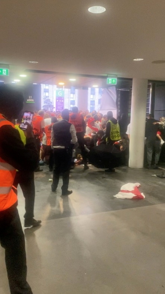 Fans attempt to get through a door meant for disabled access at Wembley Stadium before the Euro 2020 final soccer match between Italy and England, in London, Britain, July 11, 2021, in this still image obtained from video. Courtesy of Mark Lindsay / Socia