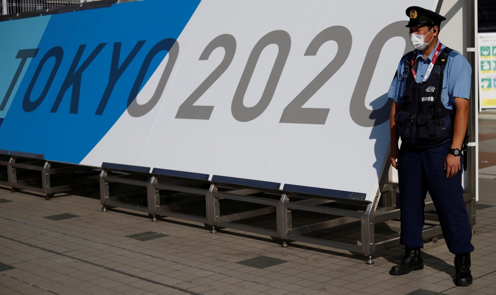 A police officer wearing a face mask stands near the entrance of the Main Press Centre, ahead of the Tokyo 2020 Olympic Games, in Tokyo, Japan, July 19, 2021. REUTERS/Phil Noble