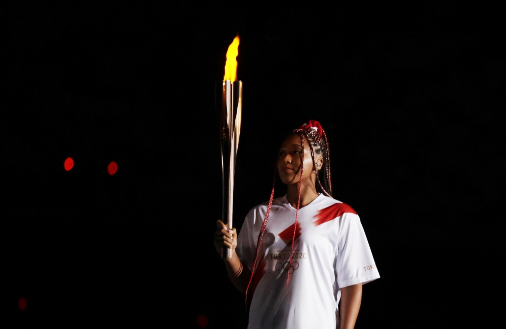 July 23, 2021 Naomi Osaka of Japan carries the Olympic torch at the opening ceremony REUTERS/Hannah Mckay