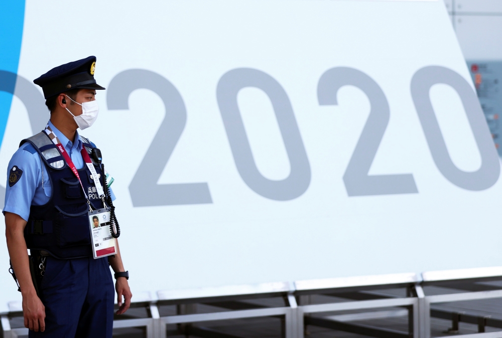 A police officer wearing a face mask stands guard during the Tokyo 2020 Olympic Games in Tokyo, Japan, July 24, 2021. REUTERS/Siphiwe Sibeko