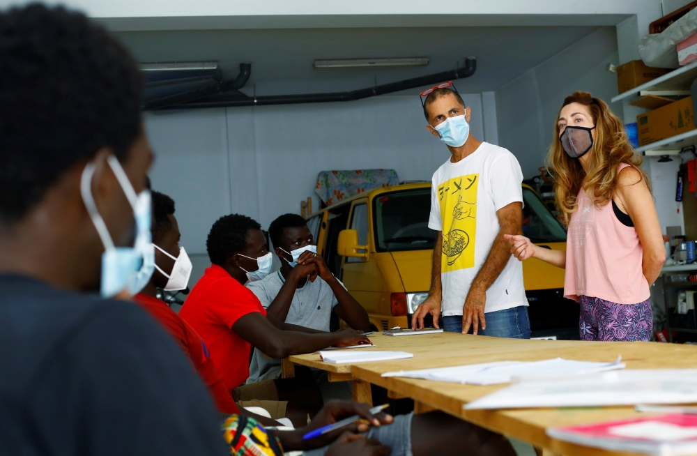 Isabel Florido and Tito Martin teach Spanish classes to a group of Senegalese migrants who arrived on the island by boat, in Las Palmas on the island of Gran Canaria, Spain July 21, 2021. Reuters/Borja Suarez