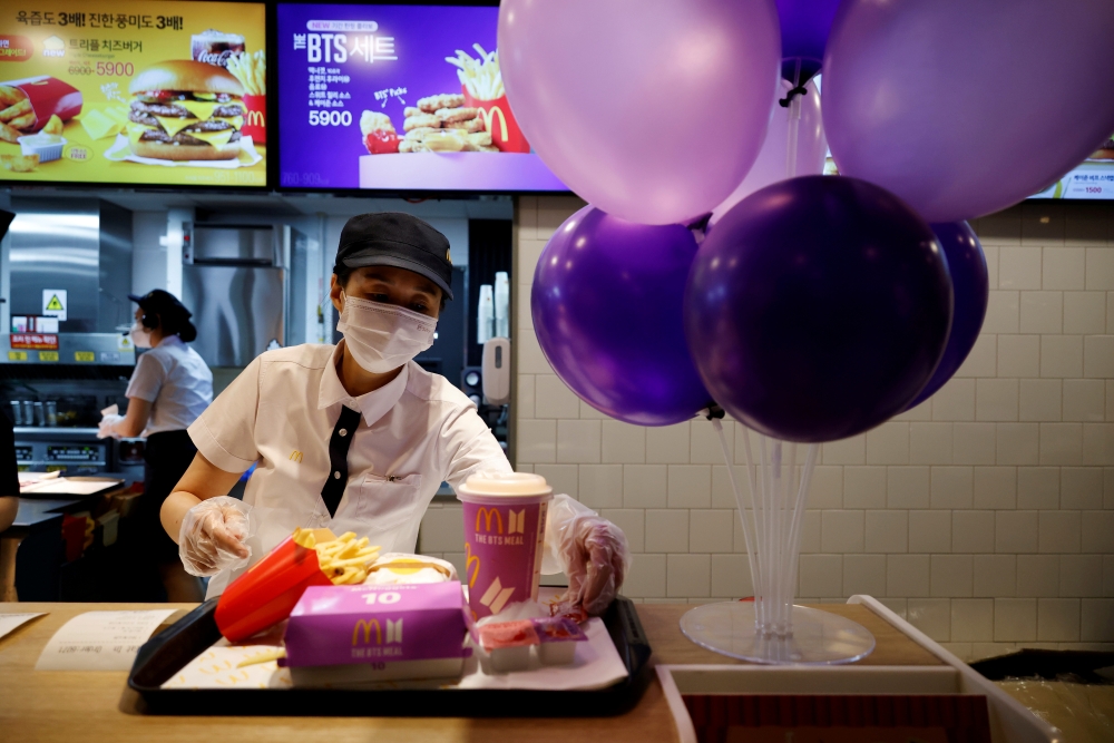 An employee of McDonald's serves a BTS meal, which is inspired and promoted by K-pop boy band BTS, during lunch hour at its restaurant in Seoul, South Korea, May 27, 2021. REUTERS/Kim Hong-Ji/File Photo