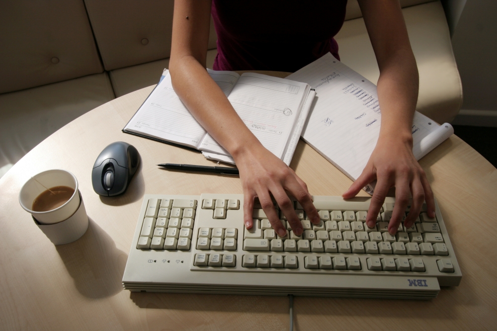 A woman works at her desk typing on a computer in this illustration picture taken January 9, 2005, REUTERS/Catherine Benson//File Photo