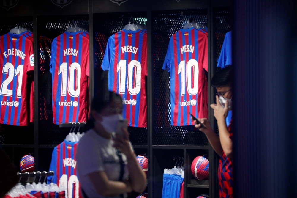 Shirts with Barcelona's Lionel Messi's name hang in the club store outside the Camp Nou. (REUTERS/Albert Gea)
