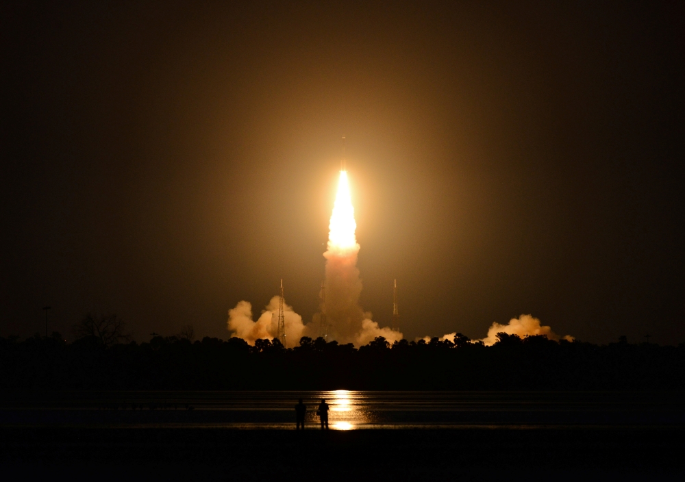 People watch as India's Geosynchronous Satellite Launch Vehicle (GSLV-F10), carrying the earth observation satellite EOS-03, lifts off from the Satish Dhawan Space Centre in Sriharikota, India, August 12, 2021. REUTERS/Stringer