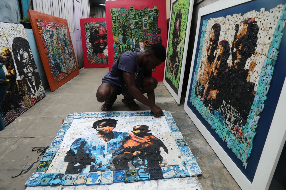 Ivorian painter Aristide Kouame 26, who paints optical effects artworks with worn soles, works at his workshop in Abidjan, Ivory Coast August 4, 2021. Picture taken August 4, 2021. REUTERS/Luc Gnago