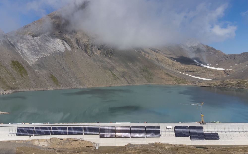 Solar panels are seen on the construction site of a large-scale photovoltaic system of Swiss energy provider Axpo at some 2500 metres above sea level on the dam of Lake Muttsee, Switzerland August 19, 2021. Picture taken with a drone, August 19, 2021. REU