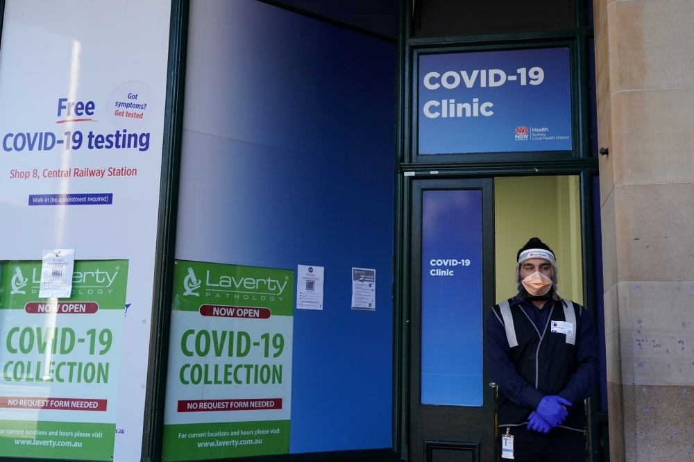  A staff member stands at the entrance of a COVID-19 clinic during a lockdown to curb a coronavirus disease outbreak in Sydney, Australia, August 20, 2021. REUTERS/Loren Elliott/File Photo