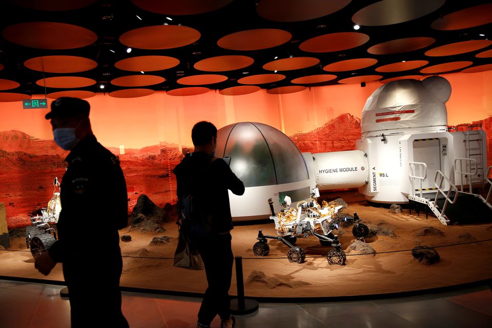 People inspect models of a Mars base and a rover displayed inside the SKP-S shopping mall in Beijing, China September 23, 2020. REUTERS/Tingshu Wang/File Photo