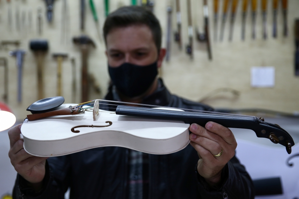 Luthier Ivan Oliveira crafts a violin from PVC piping for Locomotiva Project, a free music school for at-risk children, in Santo Andre, Brazil August 4, 2021. Picture taken August 4, 2021. REUTERS/Carla Carniel