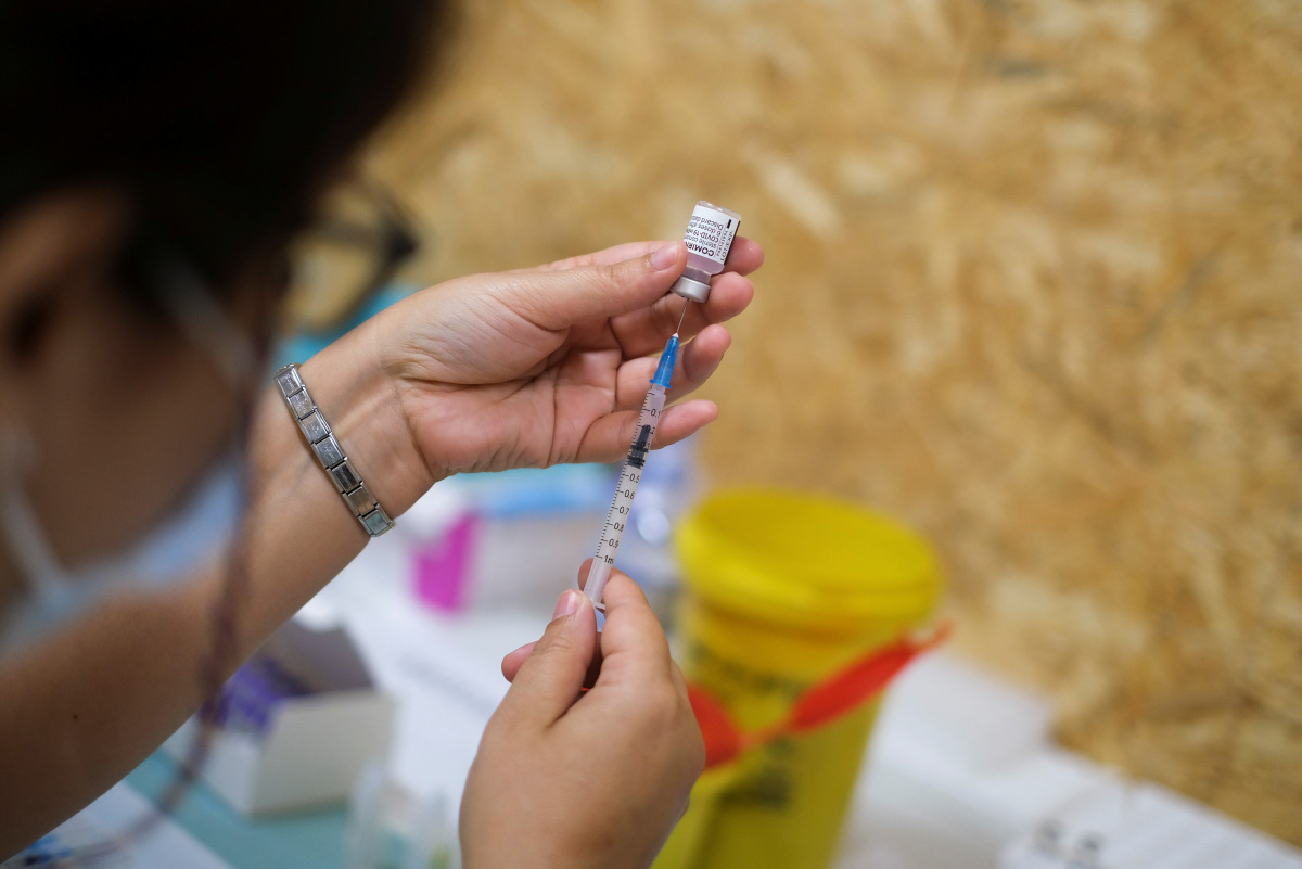 A healthcare worker prepares a dose of the Pfizer coronavirus disease (COVID-19) vaccine at a vaccination centre in Seixal, Portugal, September 11, 2021. Picture taken September 11, 2021. REUTERS/Pedro Nunes
