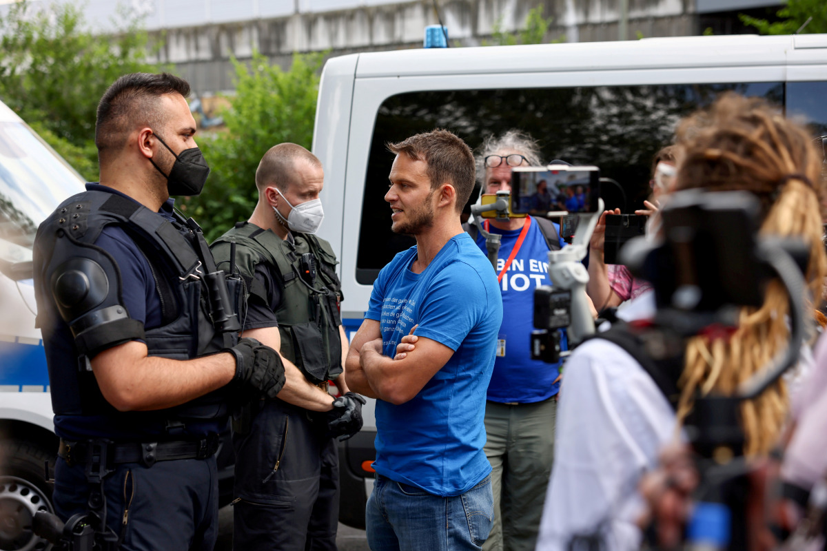 FILE PHOTO: Markus Haintz, a lawyer with the Querdenken group, speaks with police officers during a protest against the government measures to curb the spread of the coronavirus disease (COVID-19), in Berlin, Germany, July 31, 2021. REUTERS/Christian Mang