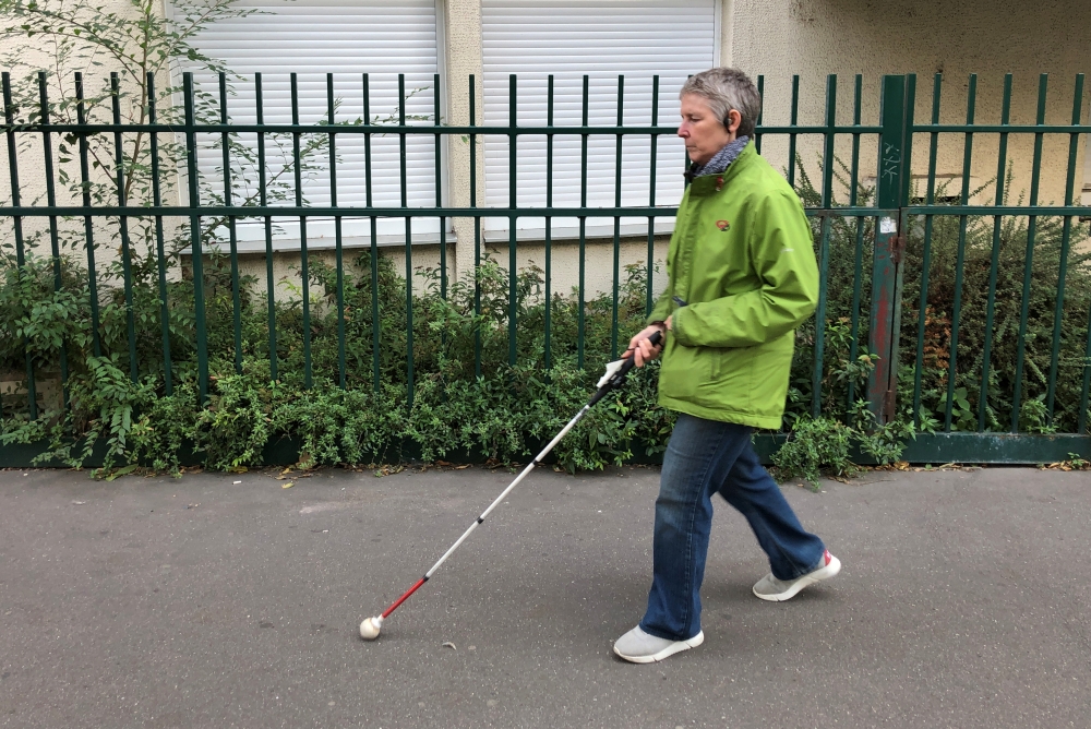 Laurence Jamet, Parisian woman blind since birth, walks with a cane and the electronic device, called Rango, invented by the Lyon-based startup Gosense, which uses sound and augmented reality to warn visually impaired people before a collision can occur, 