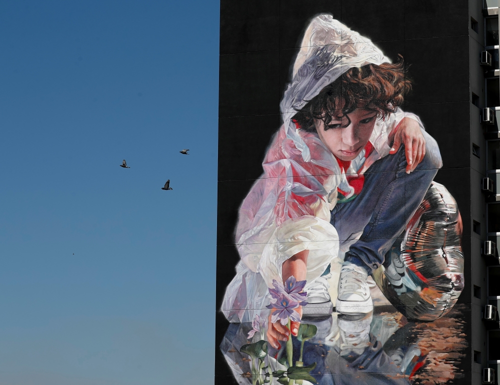 Birds fly past a mural painted by Argentine artist Martin Ron about the historical drought that has lowered the level of the country's most important river, the Parana, in San Nicolas, Argentina September 16, 2021. Picture taken September 16, 2021. REUTER