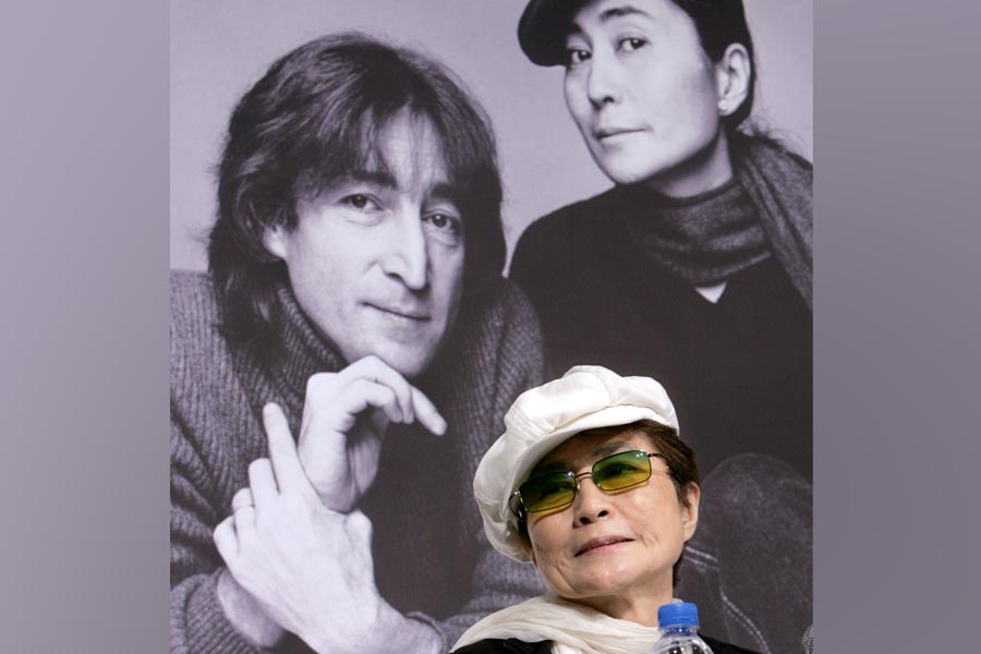 FILE PHOTO: Yoko Ono, the wife of the late singer John Lennon, listens to reporters' questions in front of a portrait of Lennon and herself at a news conference in Tokyo October 4, 2005. REUTERS/Toru Hanai/File Photo
