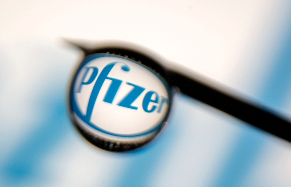 Pfizer logo is reflected in a drop on a syringe needle in this illustration photo taken March 16, 2021. REUTERS/Dado Ruvic/Illustration/File Photo/File Photo