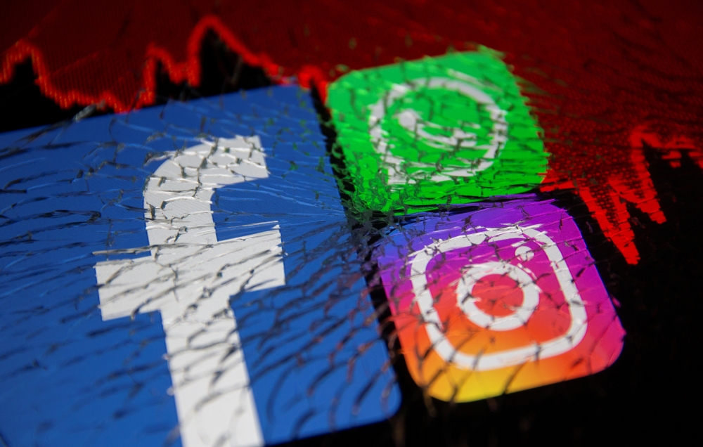 Facebook, Whatsapp and Instagram logos and stock graph are displayed through broken glass in this illustration taken October 4, 2021. REUTERS/Dado Ruvic/Illustration