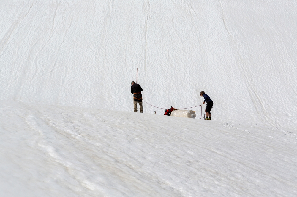 Team members Erik Huss and Oskar Kihlborg check for cracks on Helags glacier, in Sweden, June 23, 2021. Picture taken June 23, 2021. Anders Klapp/Handout via REUTERS