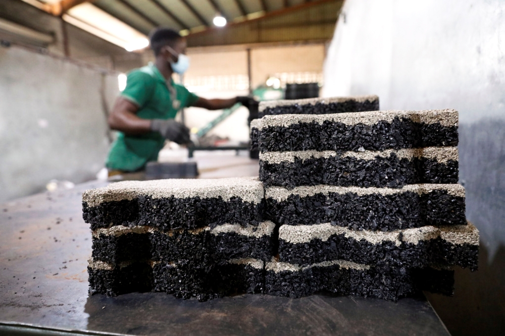 A man arranges newly moulded rubber interlocking tiles manufactured from recycled car tyres at the Freetown waste management recycle factory in Ibadan, Nigeria September 17, 2021. Picture taken September 17, 2021. Reuters/Temilade Adelaja