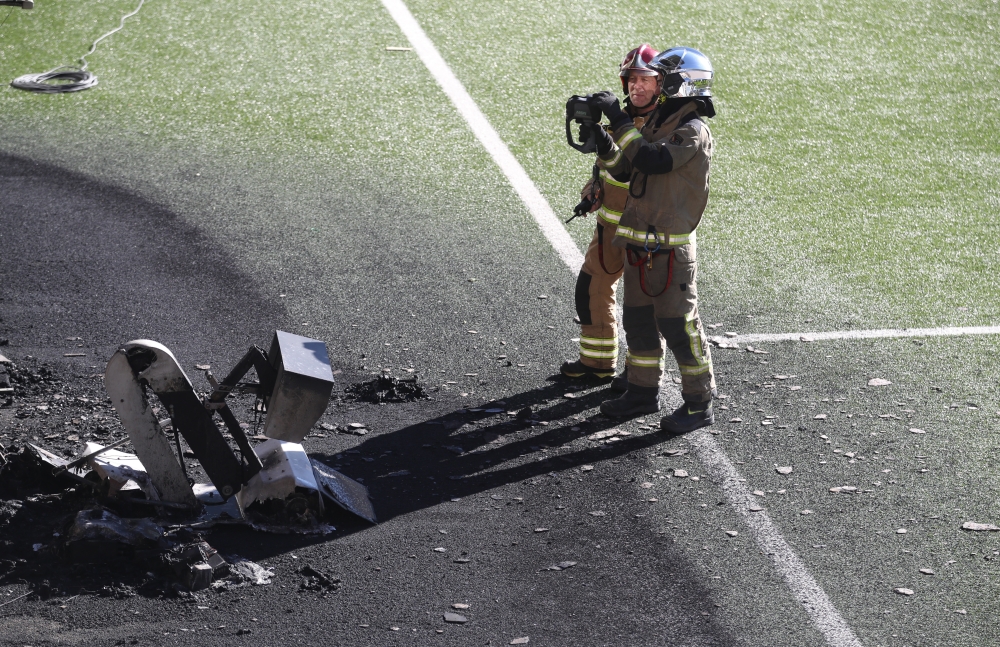 October 8, 2021 Firefighters are seen with a VAR monitor that was burnt in a fire after training Action Images via Reuters/Carl Recine