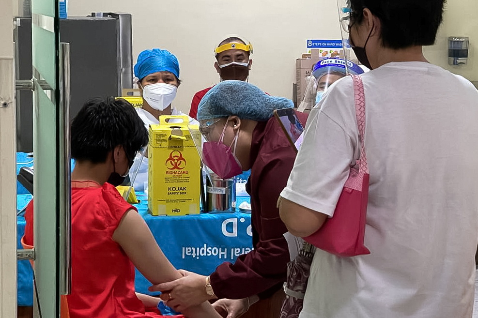 A health worker prepares to inoculate a child with Pfizer-BioNTech vaccine against the coronavirus disease (COVID-19), during the vaccine rollout for children with comorbidities, in Pasig City, Metro Manila, Philippines, October 15, 2021. PASIG CITY PUBLI