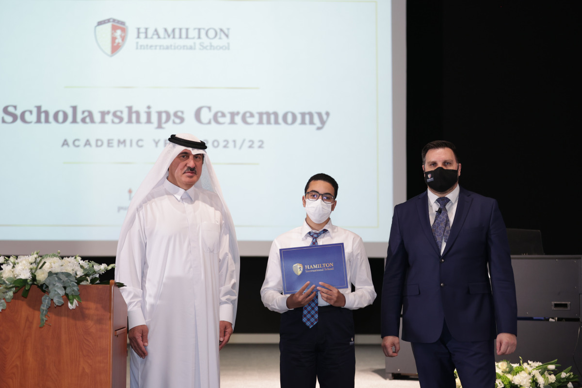 A winner of scholarship with officials at an announcement ceremony.