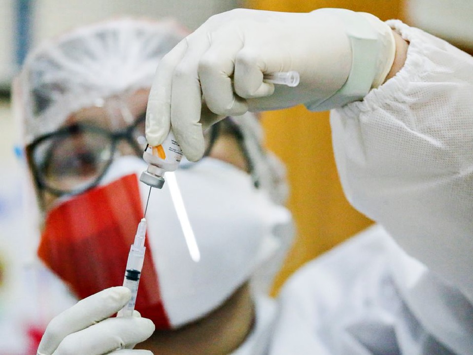A healthcare worker wearing an Indonesian flag mask to mark the country's 76th Independence Day, prepares a dose of China's Sinovac Biotech vaccine against the coronavirus disease (COVID-19) during a mass vaccination program in Jakarta, Indonesia, August 17, 2021. REUTERS/Ajeng Dinar Ulfiana