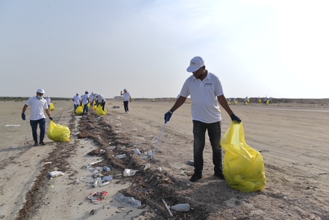 Volunteers collect waste during the clean-up event held at Al Jamail coastline.