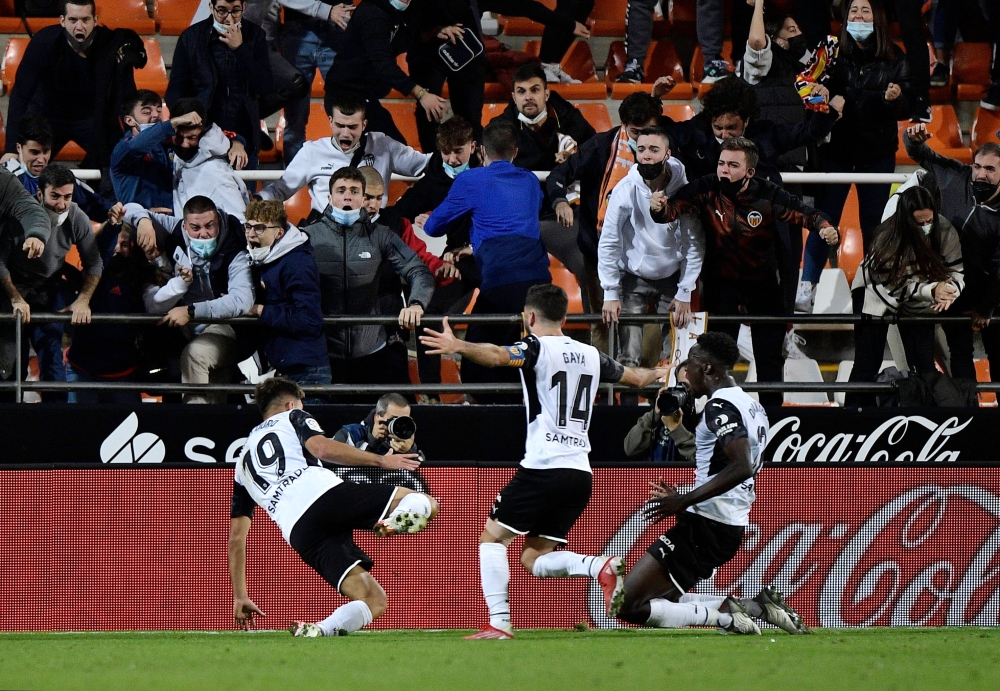 Valencia's Hugo Duro celebrates scoring their third goal with Jose Gaya and Mouctar Diakhaby REUTERS/Pablo Morano
